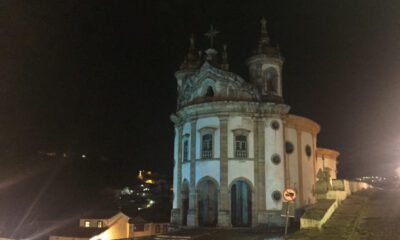 Foto de igreja à noite, mostrando a fachada arredondada pela lateral