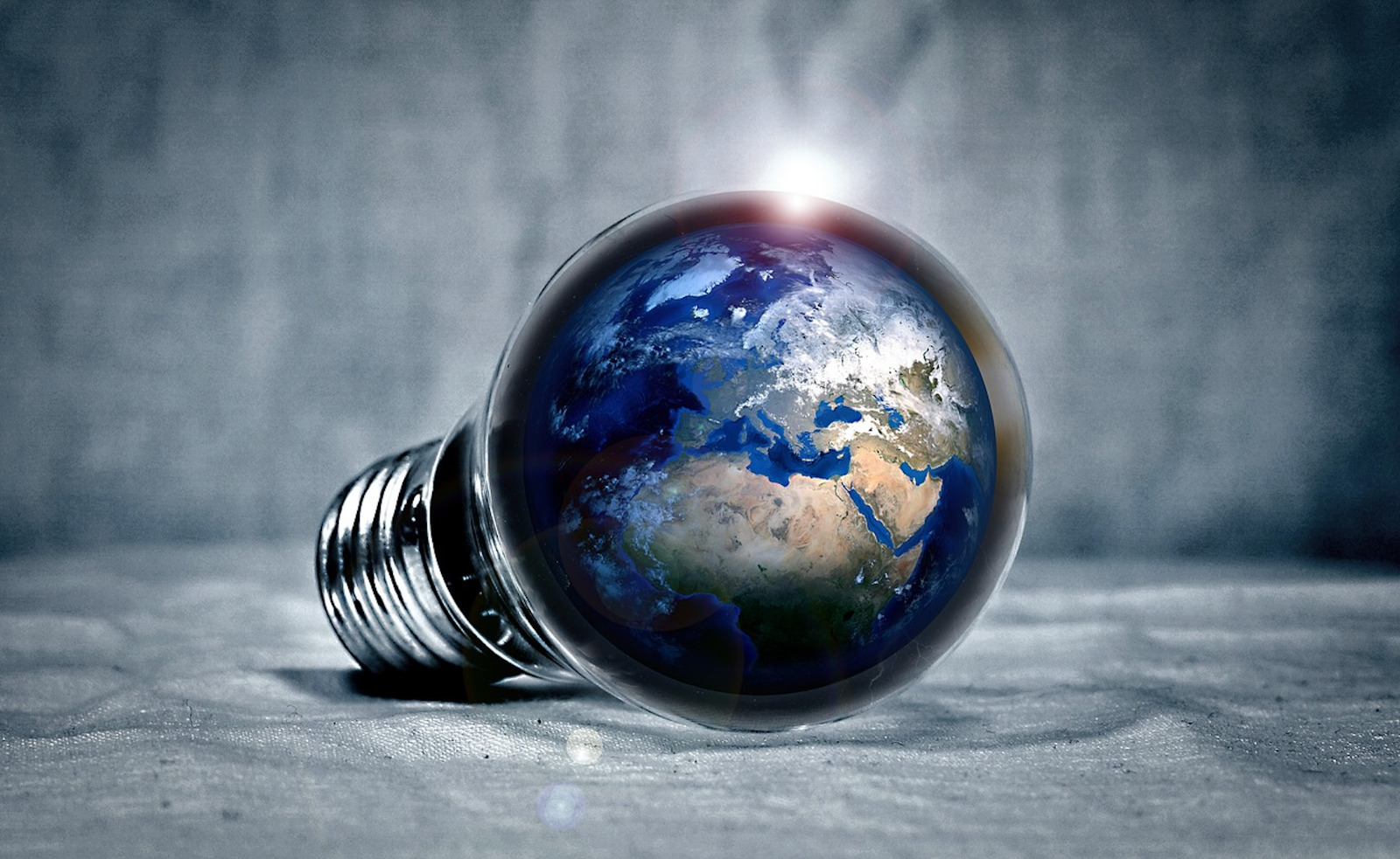 Foto de uma lâmpada sobre um tecido, com o globo terrestre por dentro.