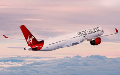 Foto de avião branco e vermelho com a marca Virgin Atlantic, sobe as nuvens.